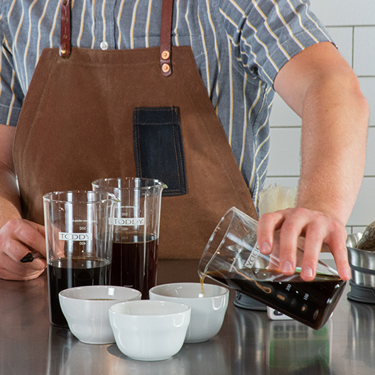 Pouring Toddy cold brew into cupping bowls
